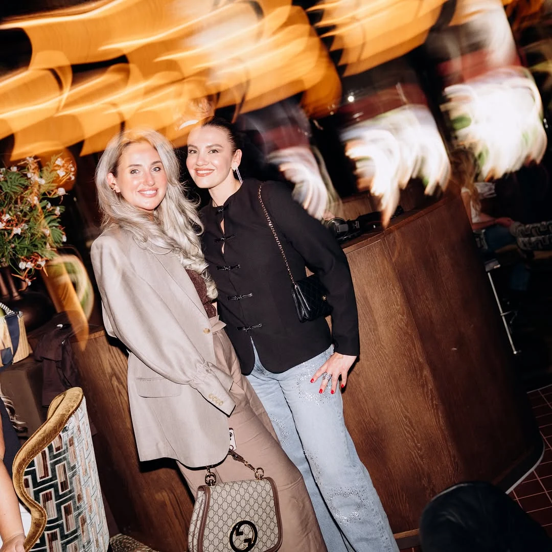 Guests laughing beneath warm pendant lights